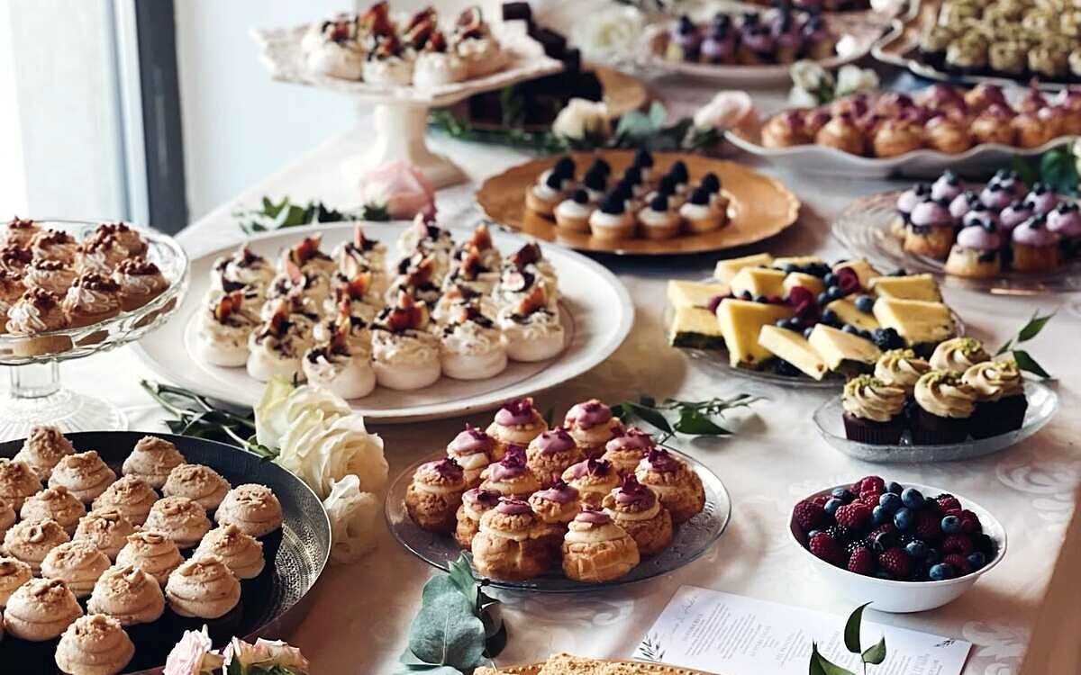 Platouri etajate cu prăjituri mici și fructe de pădure la un eveniment