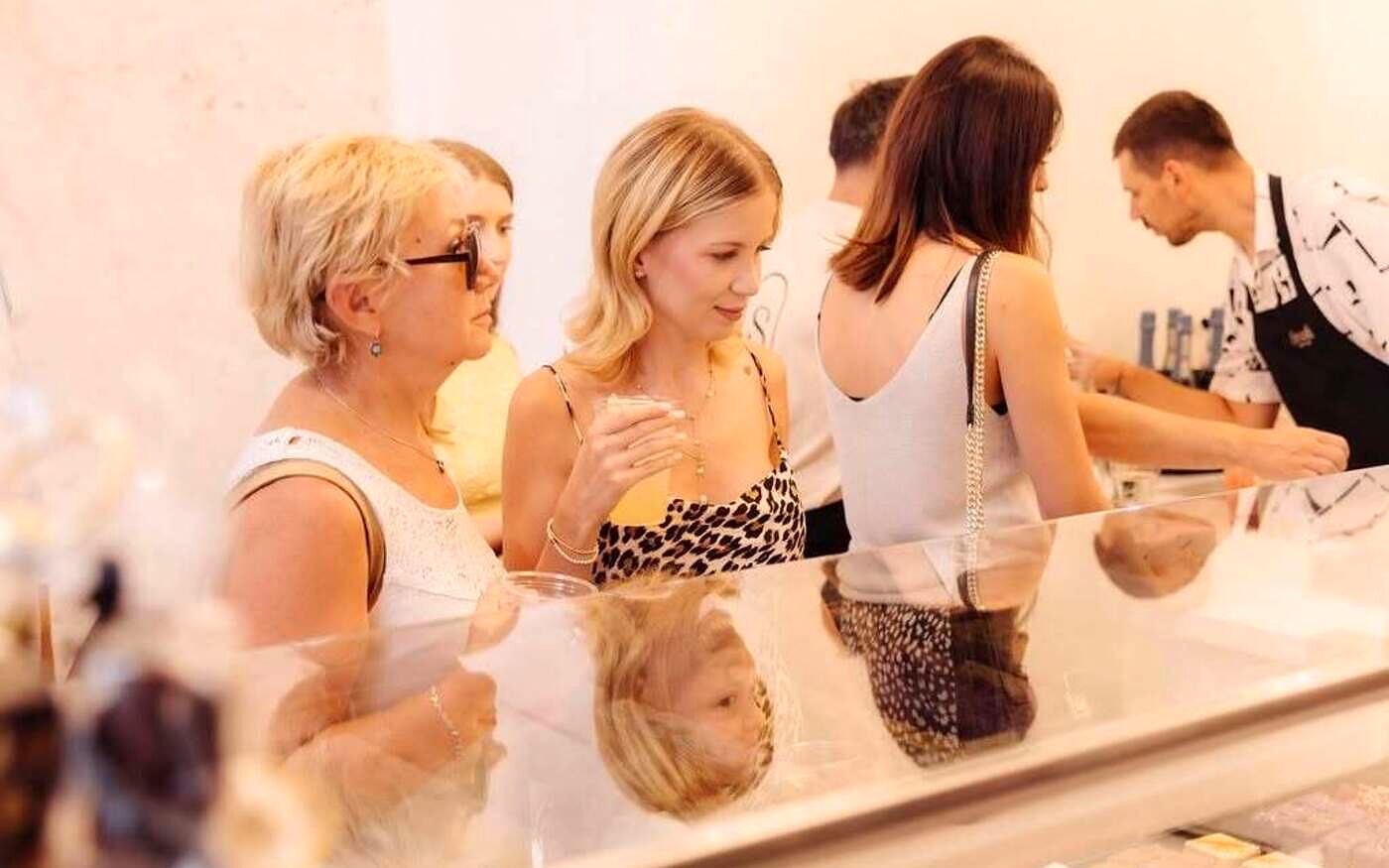 Clienți privind prăjiturile din vitrina cake shop-ului Șmafi